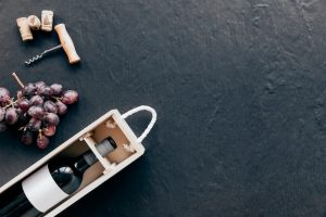 Free photo corkscrew and grape near box with wine