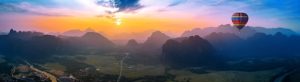Free photo aerial view of vang vieng with mountains and balloon at sunset.