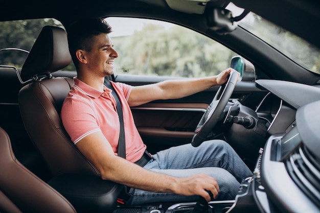Free photo handsome man driving in his car