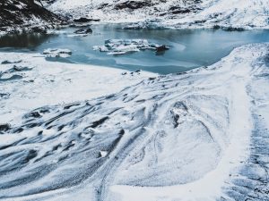 Free photo snowy white hiking roads in the rugged mountains with a frozen icy lake