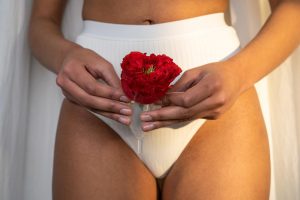 Gratuit Femme En Sous Vêtements Blancs Tenant Une Rose Rouge Dans Une Coupe Menstruelle Photos